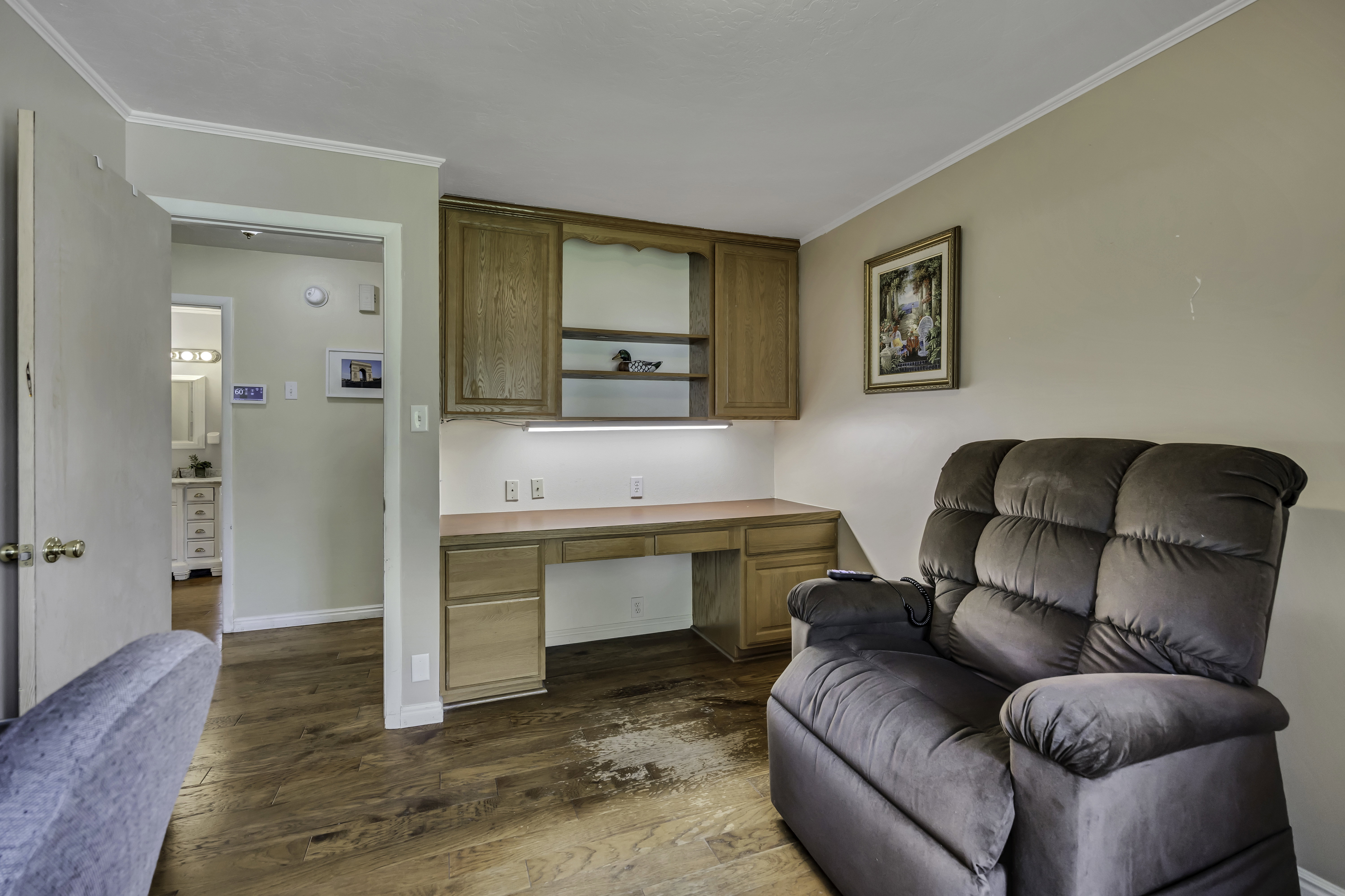 Office with built in study area, dark wood finished floors, and crown molding