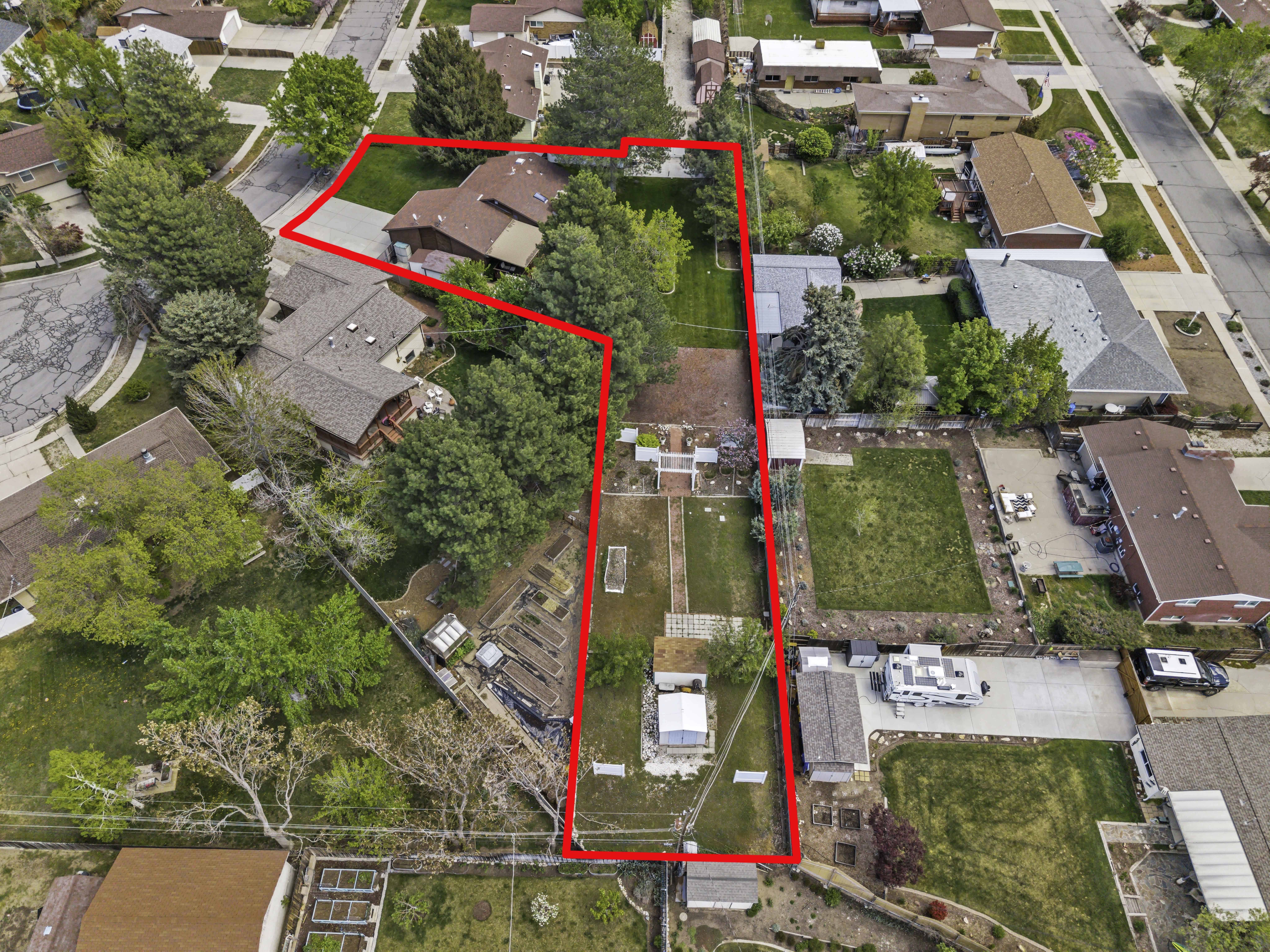Expansive property featuring a main residence with a multi-gabled roof, extensive green spaces, mature trees, and multiple outbuildings
