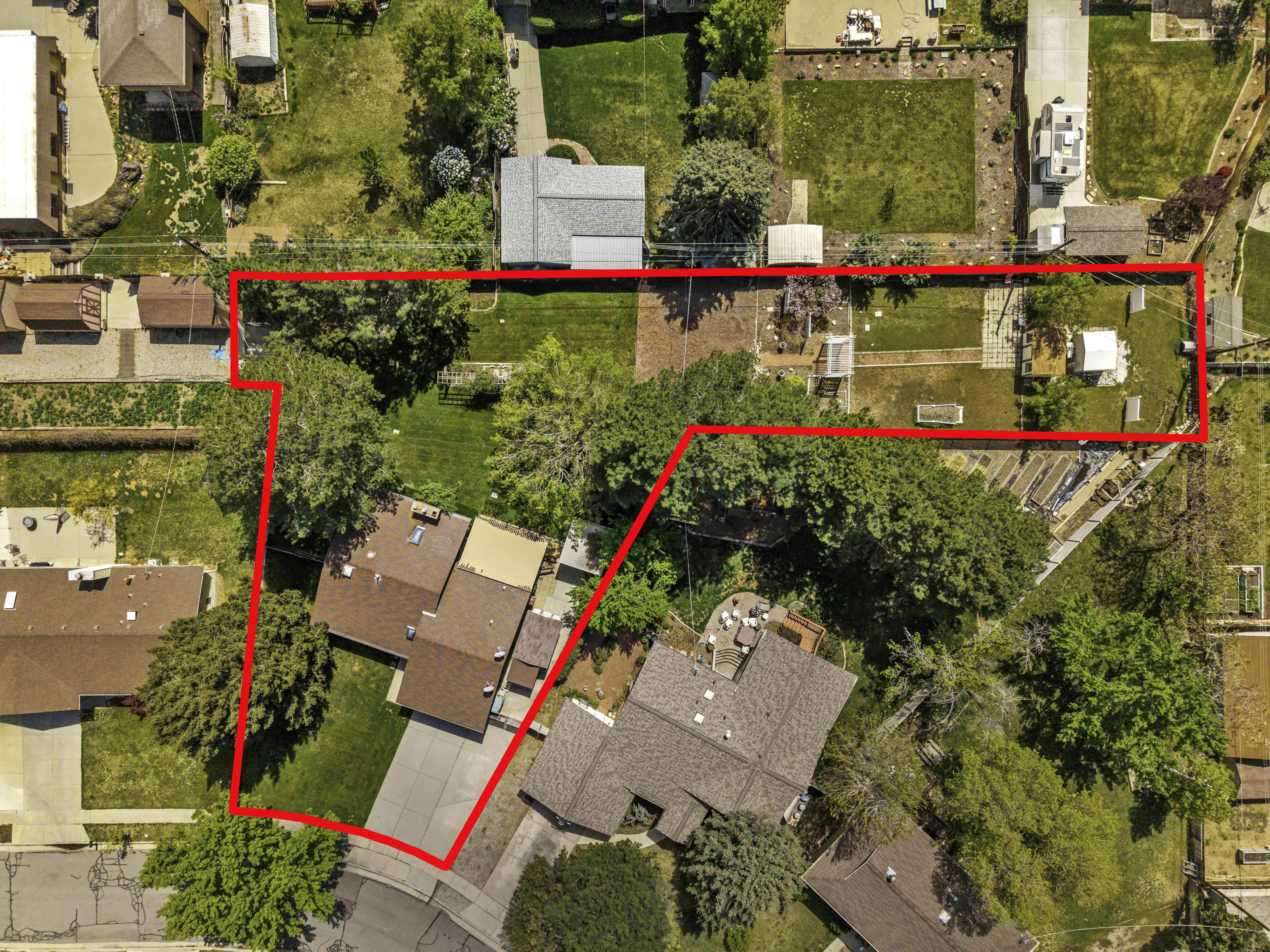 Expansive property featuring multiple structures, mature trees, and extensive green spaces