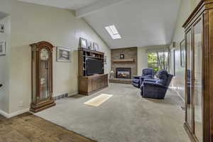 Living room featuring a fireplace, a skylight, and light wood-style floors