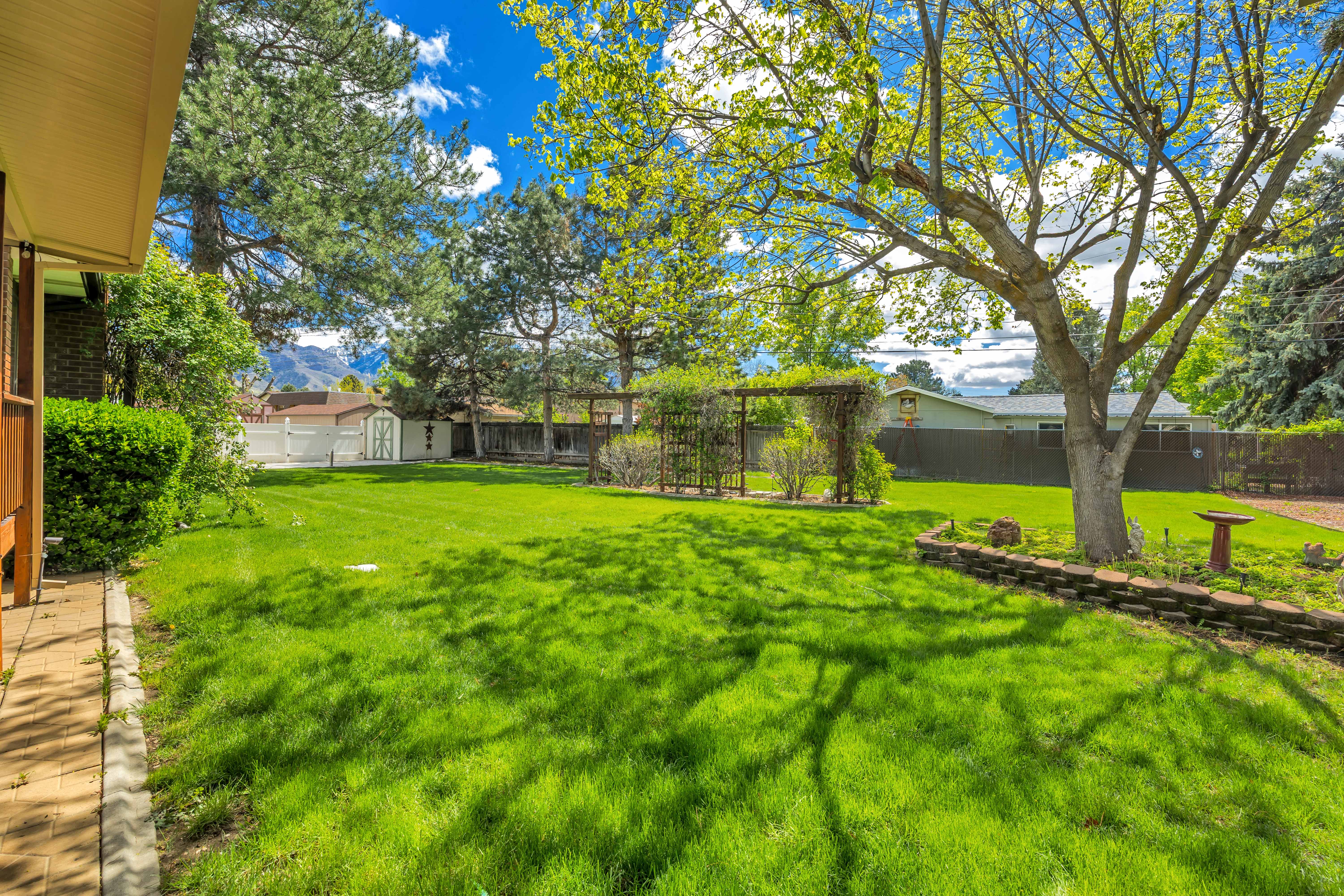 Fenced backyard featuring a shed