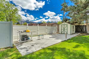 Fenced backyard with a storage shed and a mountain view