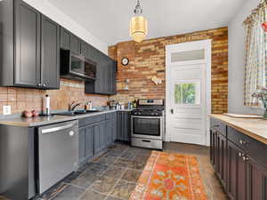 Kitchen with exposed brick and painted cabinets