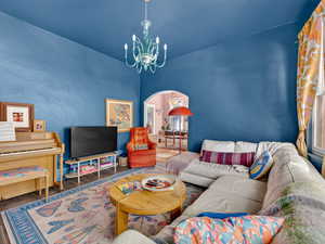 Living room has chandelier and arched doorway