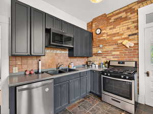 Charcoal gray cabinets and stainless steel appliances