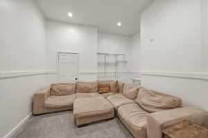Carpeted living area featuring recessed lighting and crown molding