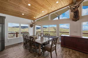 Dining space featuring a mountain view, wood tiled floors, a vaulted wood ceiling, healthy amount of natural light, and recessed lighting
