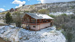 Snow covered house with a deck with mountain view