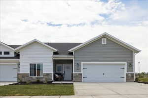 Craftsman inspired home with stone siding, driveway, covered porch, a garage, and a shingled roof