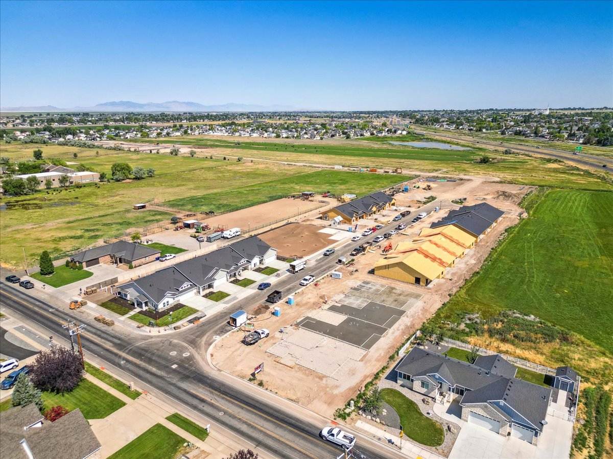 Aerial view of property and surrounding area with nearby suburban area and a large body of water