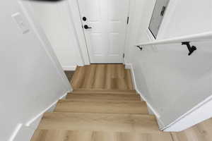 Stairway featuring wood finished floors and baseboards