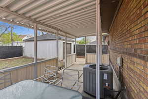 Fenced backyard with a sunroom, outdoor dining space, and an outdoor structure