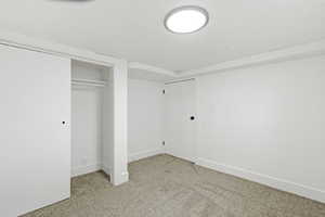 Unfurnished bedroom with light colored carpet and a closet