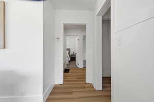 Hallway featuring light wood-type flooring and a textured ceiling