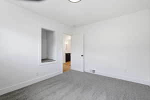 Carpeted empty room with baseboards