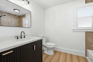 Bathroom with vanity, light wood-style flooring, a textured ceiling, and a shower