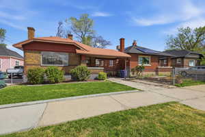 Single story home with brick siding, a chimney, and a front lawn