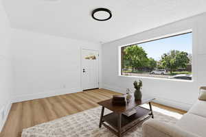 Living room featuring light wood-style flooring and a textured ceiling