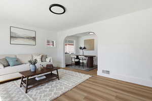 Living area with wood finished floors and arched walkways