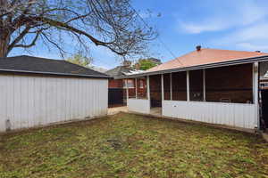 Back of house with a yard and brick siding