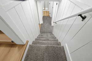 Stairway featuring wood walls