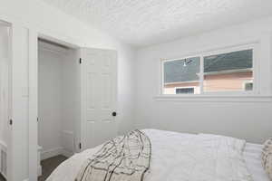 Bedroom with a textured ceiling and dark carpet
