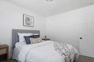 Bedroom with carpet floors and a textured ceiling