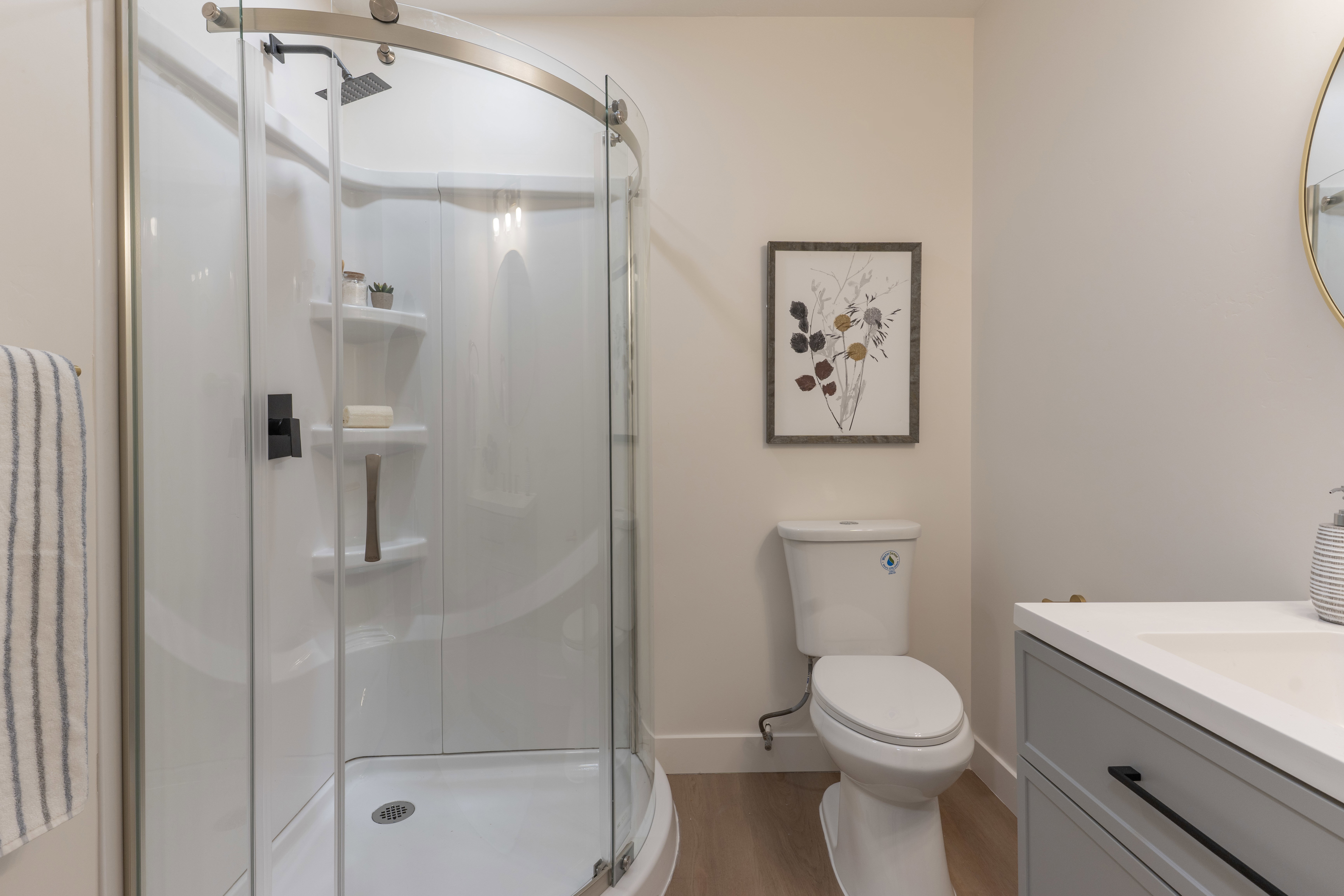 Bathroom featuring vanity, a stall shower, and light wood-style flooring