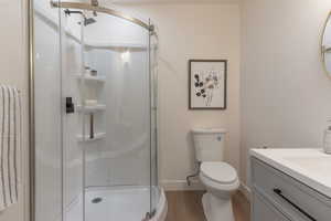 Bathroom featuring vanity, a stall shower, and light wood-style flooring
