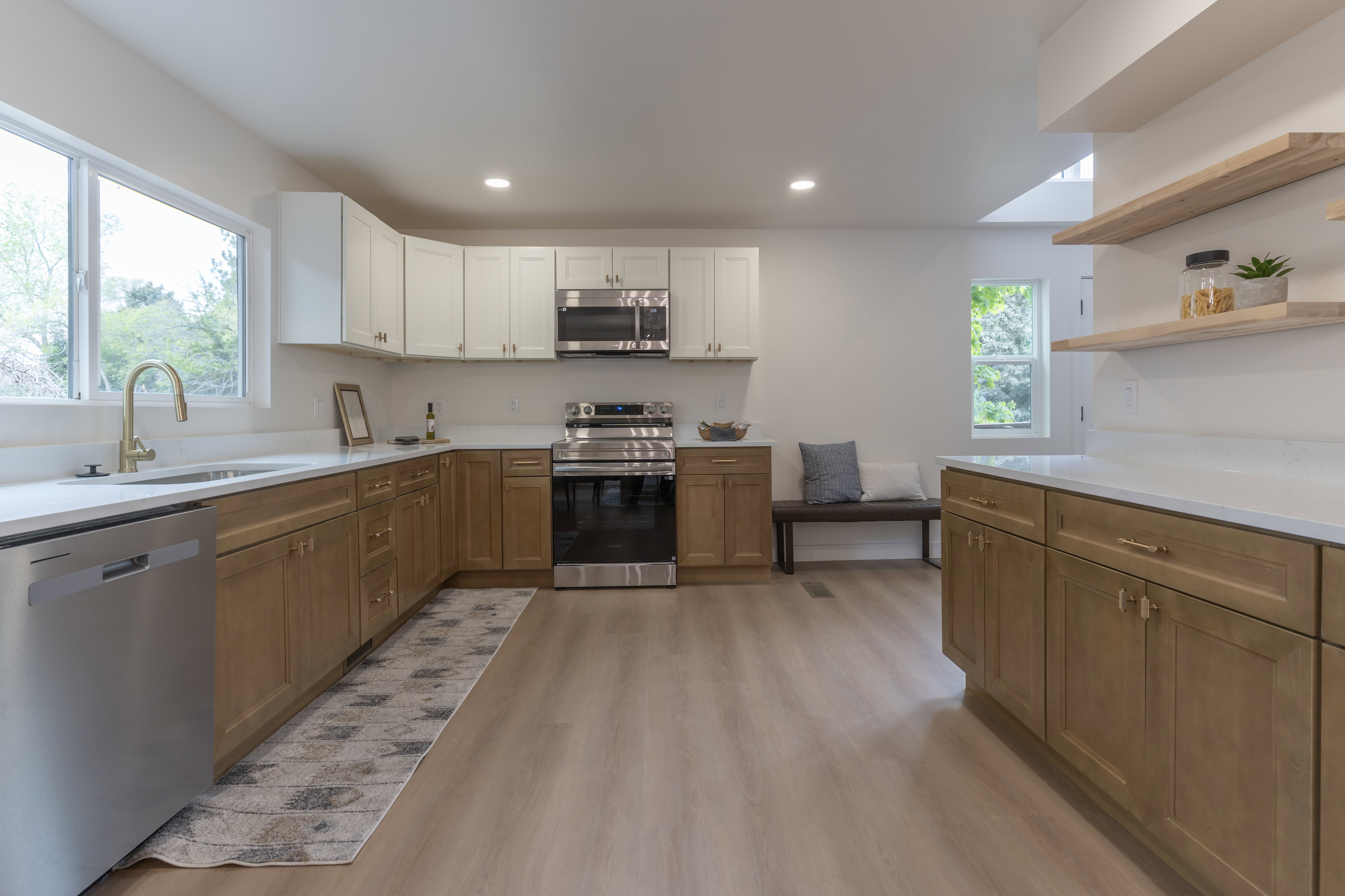 Dual tone kitchen featuring stainless steel appliances, open shelves, light wood-type flooring, two tone cabinetry, and recessed lighting