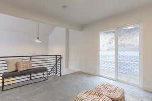 Unfurnished room with light colored carpet and vaulted ceiling with beams