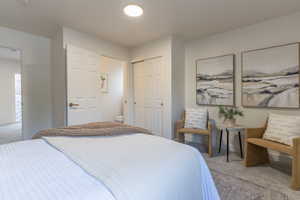 Bedroom featuring carpet flooring, a closet, and ensuite bath