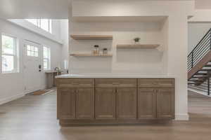 Kitchen with light wood-style flooring, wood finish cabinetry, and open shelves