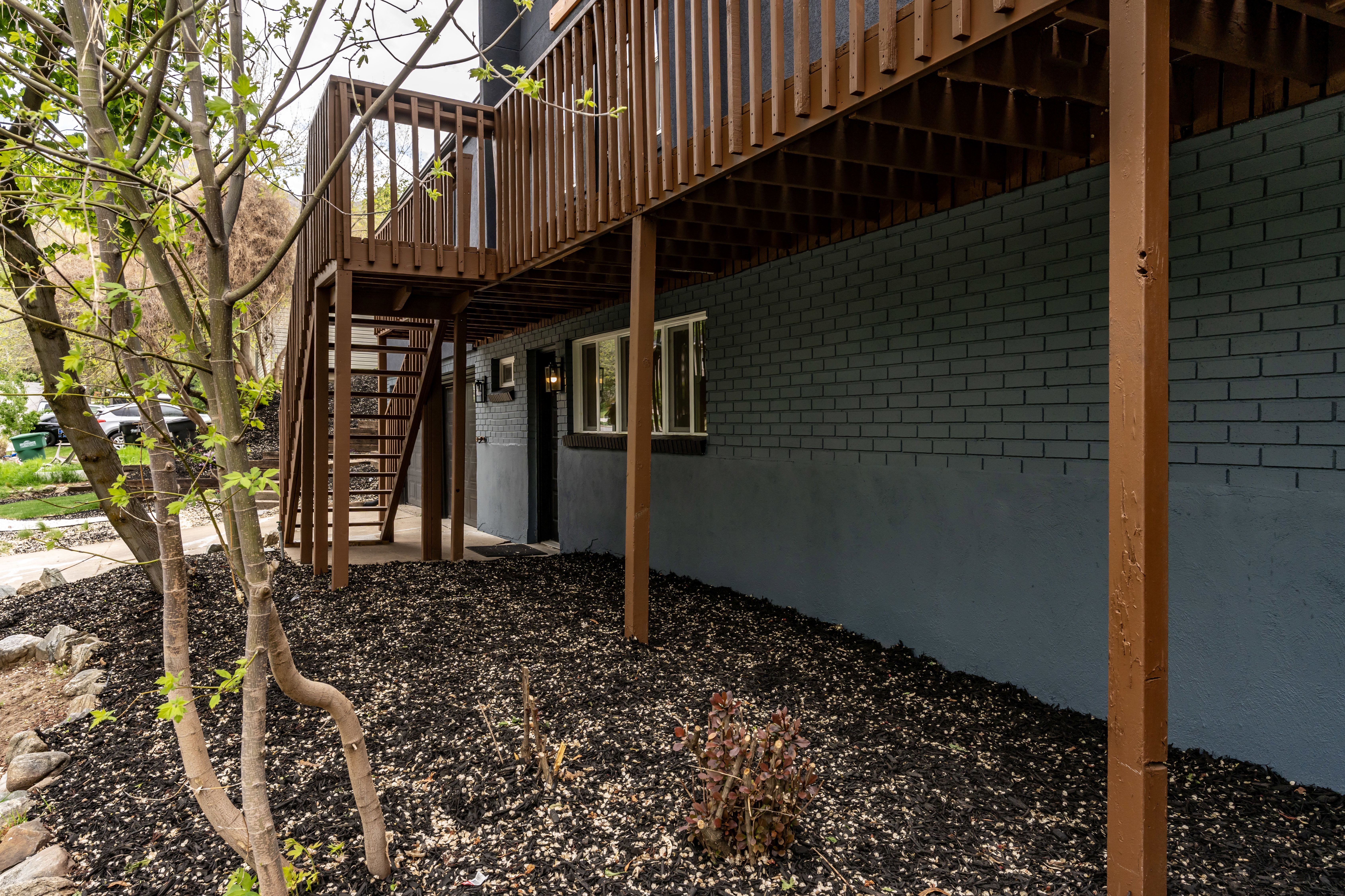 View of side of home with a deck and brick siding