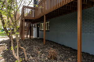 View of side of home with a deck and brick siding