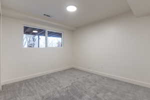 Carpeted empty room with baseboards