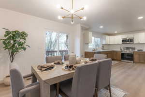 Dining space with light wood-style flooring and a chandelier