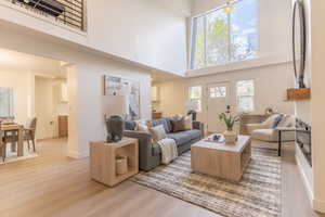 Living area featuring light wood finished floors and a high ceiling