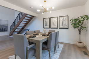 Dining space with light wood-style flooring and a chandelier