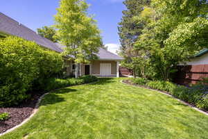 View of fenced yard with roll-up door into garage
