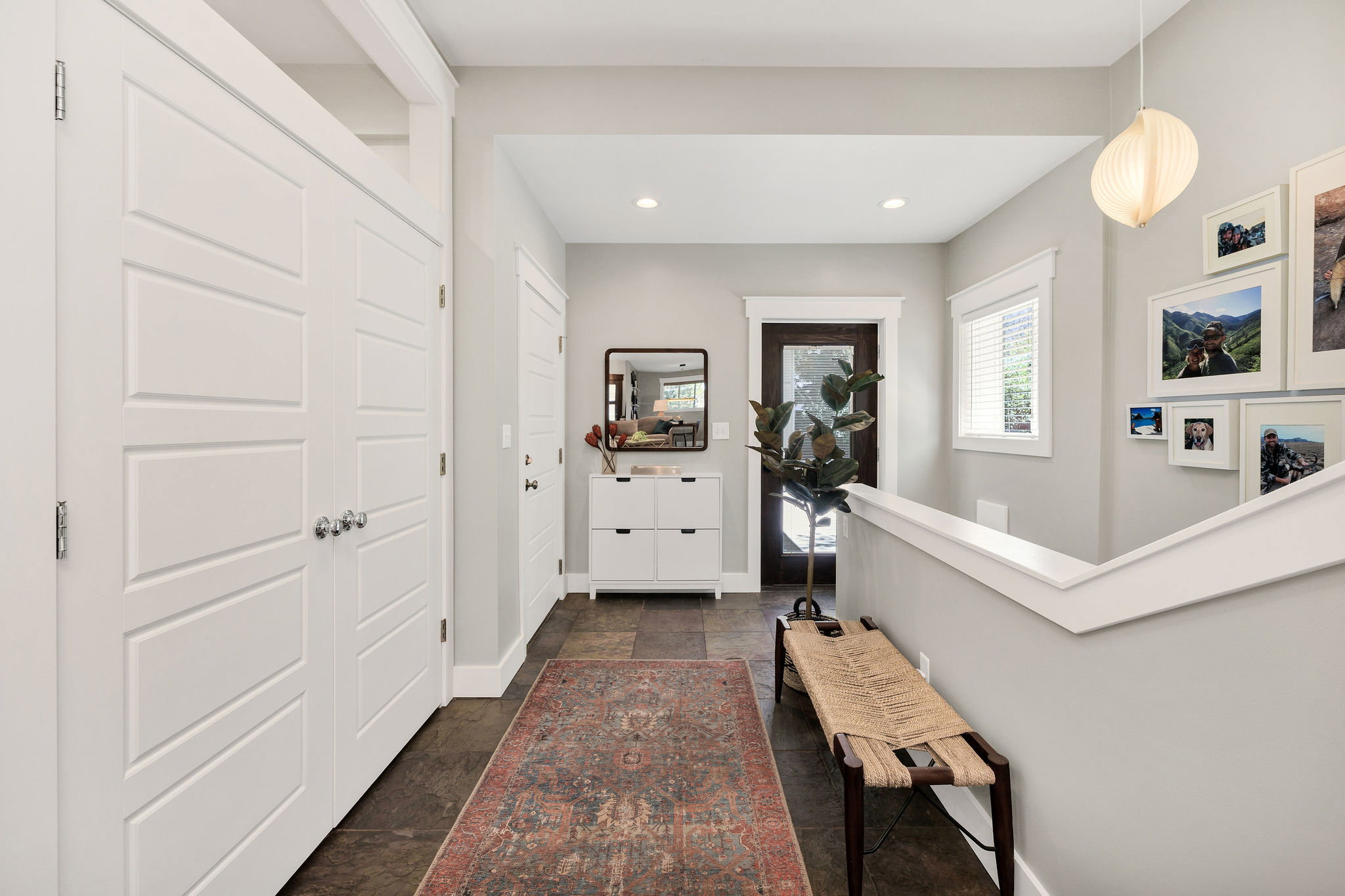 Mudroom off of garage with door to patio and laundry room and stairs to basement