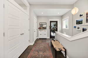 Mudroom off of garage with door to patio and laundry room and stairs to basement