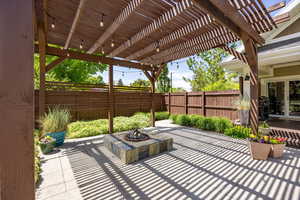 Fenced backyard with a patio, a pergola, and a gas firepit