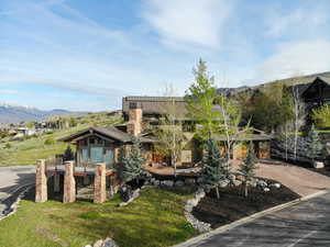 Exterior space featuring a mountain view, concrete driveway, a balcony, and a lawn
