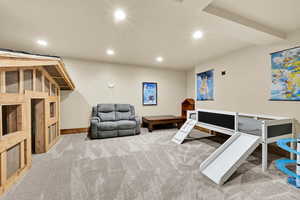 Living area with recessed lighting and light carpet