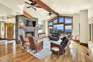 Living area featuring a stone fireplace, light wood-style floors, ceiling fan, and recessed lighting