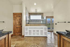Bathroom with vanity, plenty of natural light, stone tile flooring, tiled shower, and recessed lighting