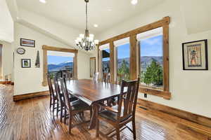 Dining room featuring a mountain view, hardwood / wood-style flooring, plenty of natural light, a chandelier, and vaulted ceiling