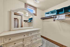 Walk in closet featuring dark colored carpet