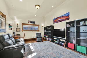 Living area with lofted ceiling, recessed lighting, and dark wood finished floors